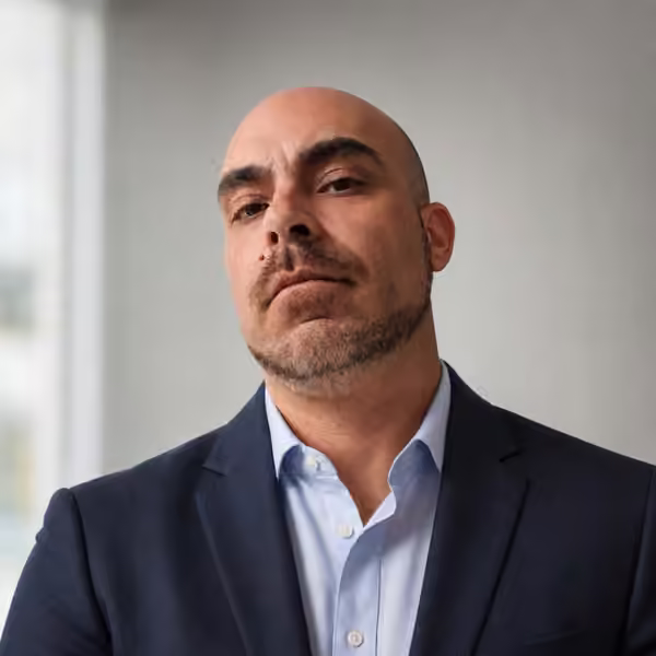 Jimi Maciel, MileMogul founder, in a navy suit jacket and light blue shirt